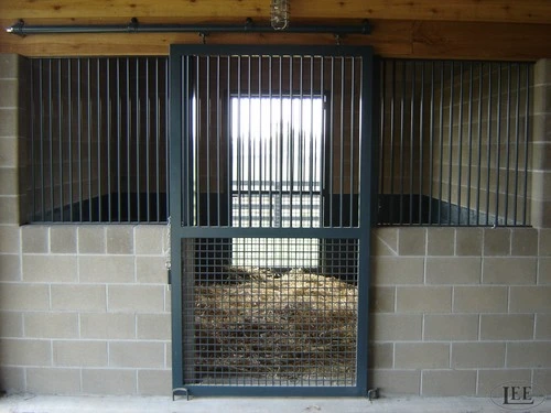 Gray painted sliding stall door with vertical bars and mesh ventilation panel
