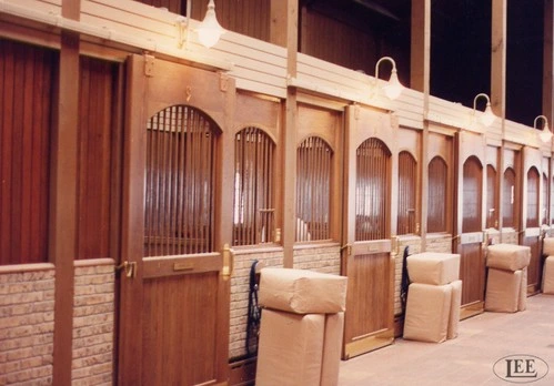 Long row of polished wood stall fronts with rounded arch tops