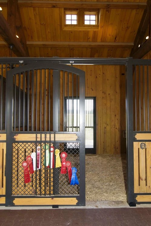 Dark wood vertical bar doors with decorative mesh grills in interior barn setting