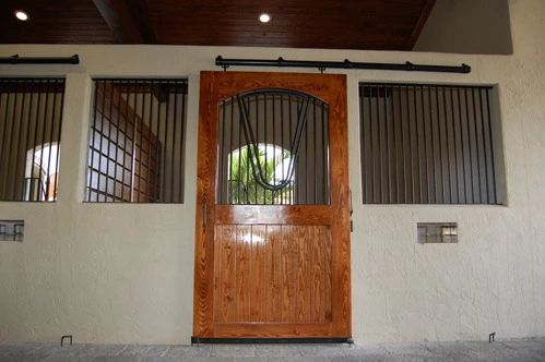 Stall fronts with carved arched wood doors and wire mesh grills