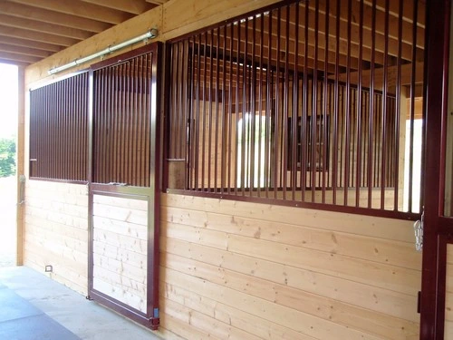 Horse stalls with vertical wood slat doors and cream-colored lower panels