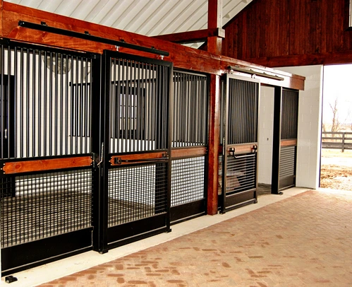 Covered outdoor area with burgundy and black stall fronts featuring wire mesh panels