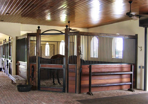 Close-up mahogany stall front with wire mesh panel and ornate hanging pendant light