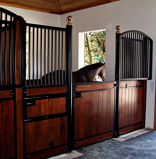 Black metal arched stall front with mahogany lower panel and bay horse visible inside