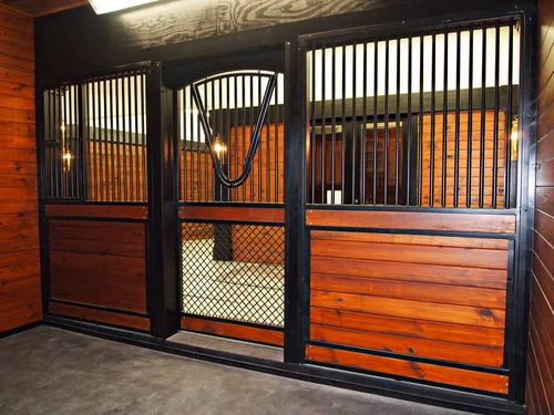 Black metal stall fronts with rich mahogany horizontal plank lower panels and wire mesh sections