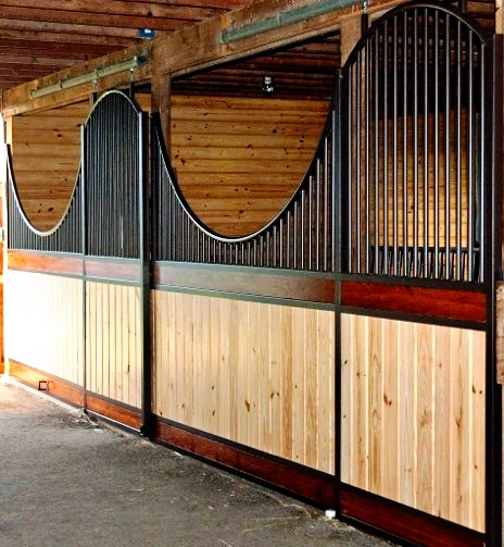 Galvanized corrugated metal and natural pine stall fronts with decorative rope swags in timber-frame barn