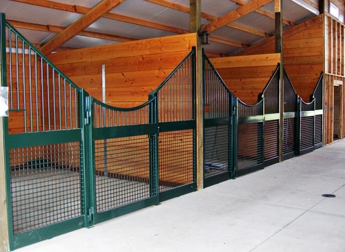 Forest green stall fronts with natural pine lower panels, wire mesh doors and corrugated metal upper grills
