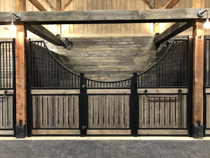Weathered wood stall front with black metal frame, vertical bar upper grill and decorative rope swag
