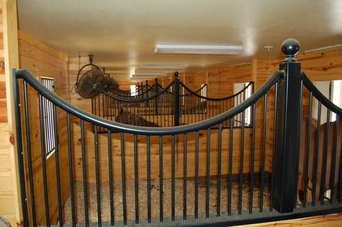 Black metal curved stall fronts with vertical bar upper grills and decorative rope swags