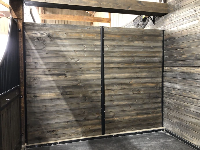 Weathered gray horizontal wood plank stall walls in corner configuration