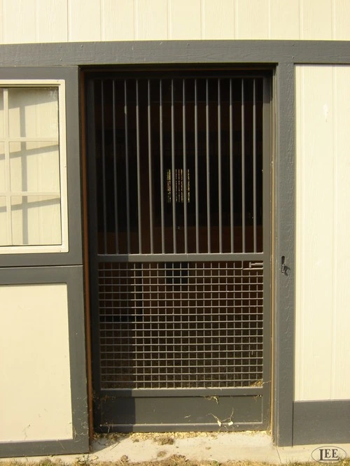 Dark charcoal stall door with vertical bars on upper section and grid mesh panel on lower half