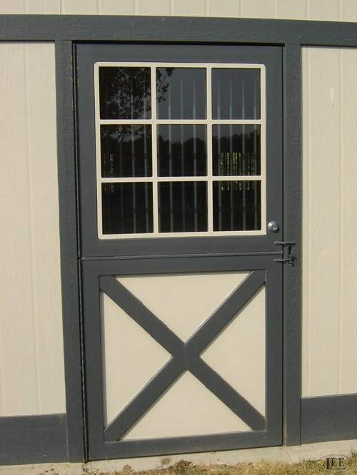 Black metal Dutch door with multi-pane window upper section and X-brace lower panel on cream wall