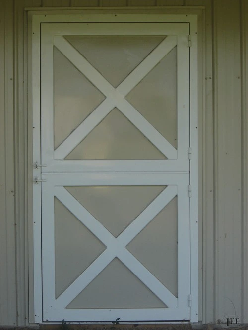 Sage green door with triangular geometric panel design centered on cream wall