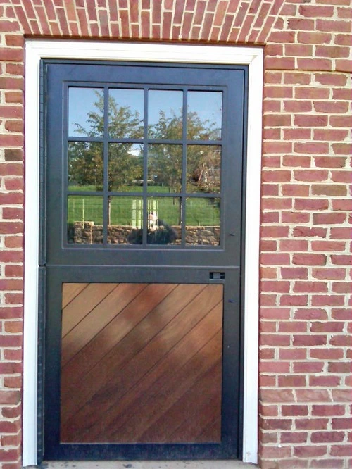 Slate blue metal Dutch door with multi-pane window upper section and wood lower panel on red brick