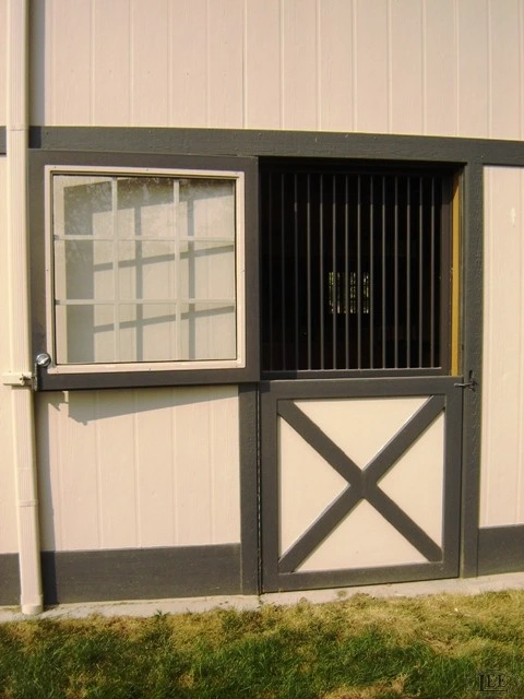 Cream and black Dutch door with vertical bar grill upper section and diagonal X-brace lower panel