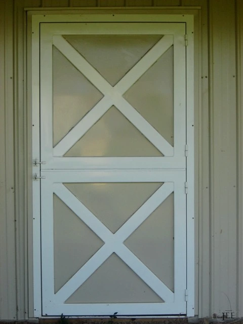 Sage green Dutch door with diagonal geometric panel design centered on cream colored wall