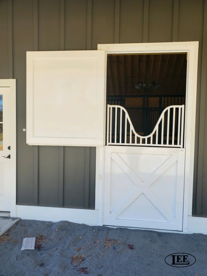 Gray and white Dutch door with curved arch top grill design on modern barn interior