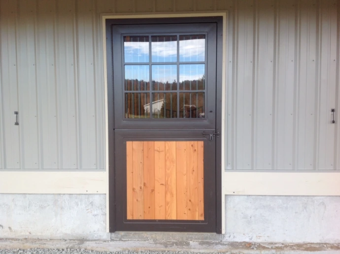Gray metal Dutch door with window upper section set in white corrugated metal wall