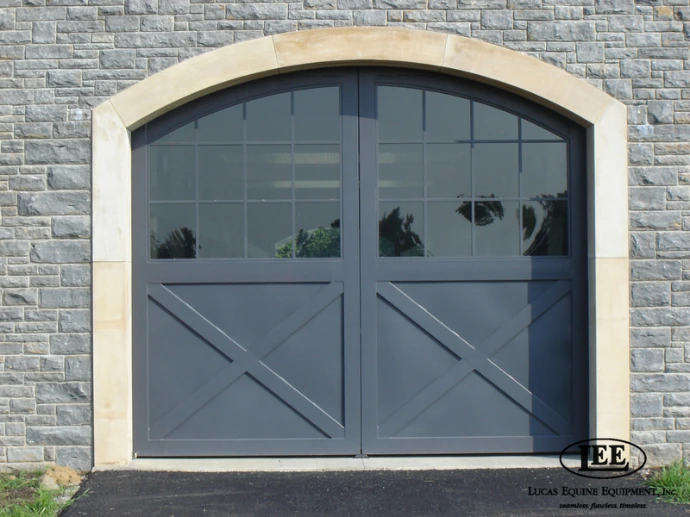 Arched grey Aisle Entry Door with a stone facade