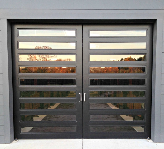 Modern gray metal doors with horizontal slat ventilation panels between stone pillars