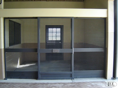 Gray metal three-bay stall front with wire mesh panels and center window opening