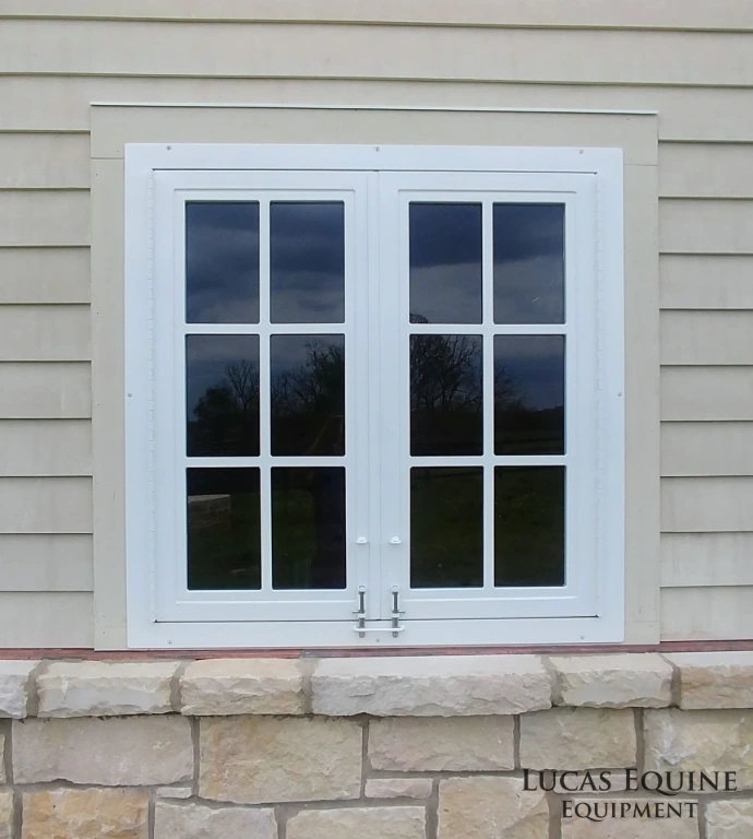 White painted traditional double-hung windows with divided panes on gray horizontal siding