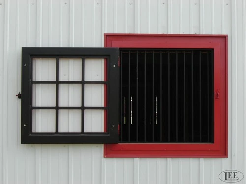 Black metal sliding window with frosted glass panels on white wall with red painted frame detail