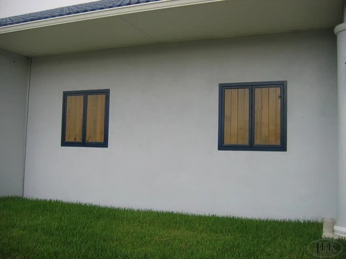 Gray stucco barn wall with black framed rectangular windows