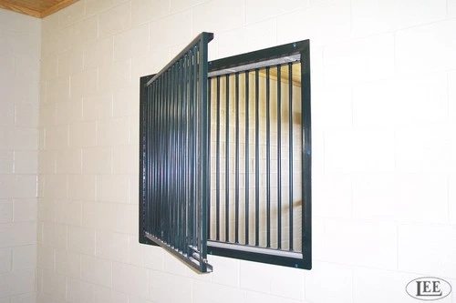 Dark charcoal vertical bar window hinged open on cream colored interior wall