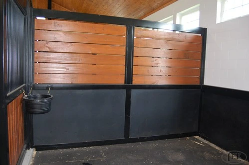 Modern barn aisle with mahogany horizontal plank stall walls and black powder-coated lower kick panels