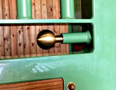 Brass Spring Bolt Latch: Mint green stall door with brass circular flush mount latch hardware on natural wood backing